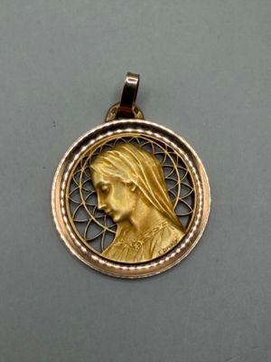 une photo d'un pendentif en or sur lequel figure le portrait d'une femme