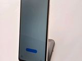 the back of a smartphone with a blue button on the display