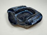 un saladier noir et bleu posé sur une table blanche