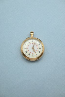 une petite montre de poche en or sur un fond bleu