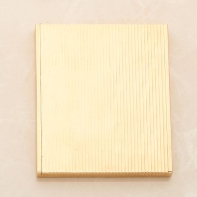 yellow gold plated square shaped box on a beige background