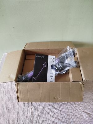 une boîte en carton contenant un livre, posée sur un lit