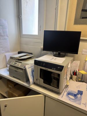 un micro-ondes et un ordinateur posés sur un bureau dans une petite pièce