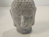 a small statue of a buddha head sitting on a table