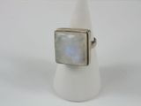 a close up of a ring with a white stone on it