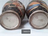 pair of asian vases sitting on a white surface with a white background