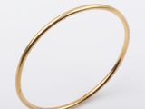 a close up of a gold ring on a white background