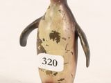a small bronze penguin with a tag on it ' s neck