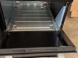 an open oven with a drawer in the middle of it