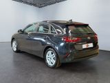 the back end of a grey car in a white room