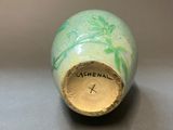 a small vase with a green and white design on it