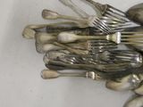 many forks and spoons laying on a white surface