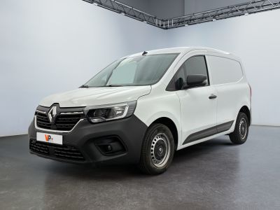 La camionnette blanche est garée dans une grande pièce.