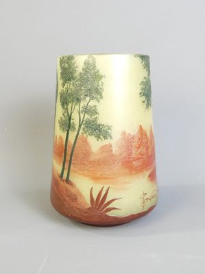 un vase avec un tableau posé sur une table