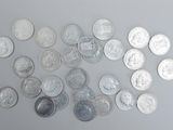 a lot of silver coins on a white surface