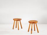 deux tabourets en bois posés sur une surface blanche