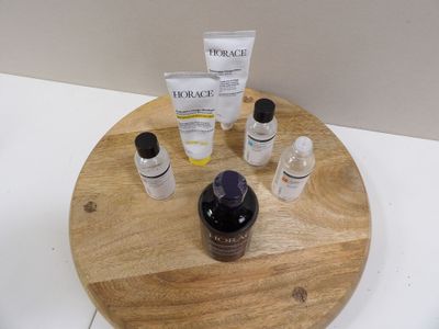 un plateau en bois sur lequel sont disposés de nombreux produits de soin pour la peau
