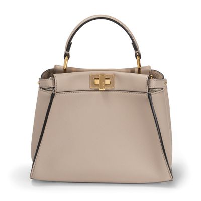 a beige leather handbag with a metal handle