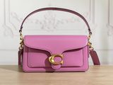 a close up of a pink handbag on a wooden table