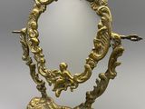 une image représentant un miroir à cadre doré posé sur un socle
