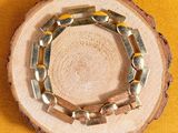 a wooden slice with a bracelet on it on a yellow background