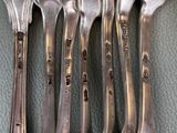 five silver spoons and two silver spoons on the table