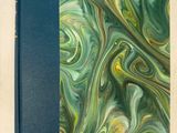 un livre avec une couverture bleue ornée d'un motif en spirale vert