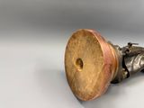 une statue en bronze représentant un homme tenant un objet en bois