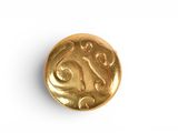 a close up of a gold coin on a white surface