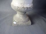 a white vase sitting on top of a gray table
