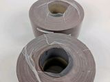 two rolls of gray tape sitting on top of a white surface