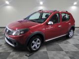 une photo d'une Dacia rouge garée sur un sol à damier