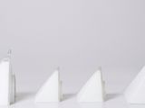 quatre triangles blancs sont alignés en rangée sur une surface blanche