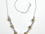 a close up of a necklace on a white surface with a chain
