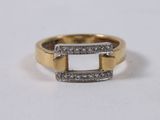 a close up of a gold and white diamond ring on a white surface