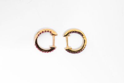 deux paires de boucles d'oreilles en or ornées de grenats sur fond blanc