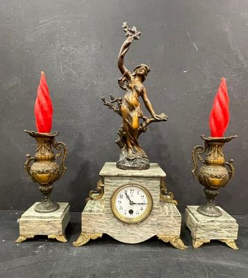 a clock that is sitting on a table next to two vases