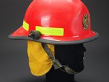 red fireman ' s helmet with yellow safety vest on a black mannequin head