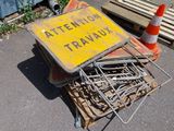 a pile of nails on the ground next to a traffic sign