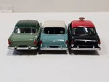 three toy cars are lined up in a row on a white surface