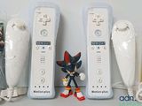 three nintendo wii remotes sitting next to each other on a table