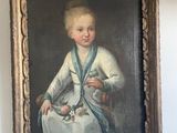 portrait of a young boy in a white dress with a blue sash
