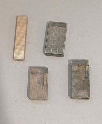 quatre briquets posés les uns à côté des autres sur une table blanche