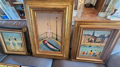 trois photos encadrées représentant des bateaux, posées sur un canapé dans un salon