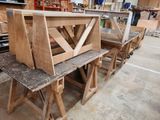 several wooden benches are lined up in a workshop with a workbench