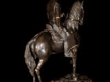 bronze statue of a man on a horse with a hat on