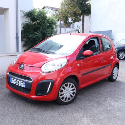 a small red car parked on the side of the road