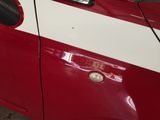 a close up of a red car with a white stripe on it