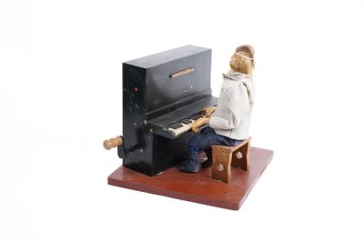une figurine représentant une femme assise au piano