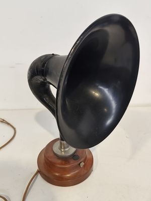 un vieux téléphone à cornet noir posé sur un socle en bois